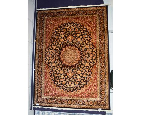 A Caucasian motif carpet/wall hanging, with central rosette over black ground with allover floral pattern, red spandrels and 