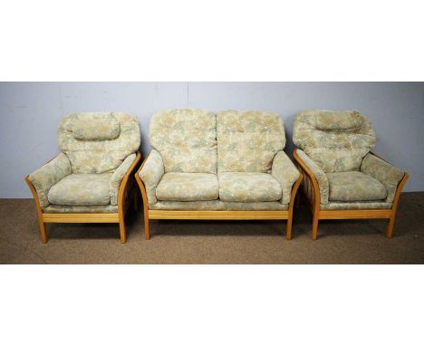 An Ercol three-piece suite comprising: a two-seater sofa with cushioned back, sides and seats contained within an elm frame; 