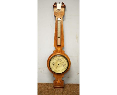 An early 20th Century mahogany barometer, the broken swan pediment above a silvered thermometer and barometer wheel with inla