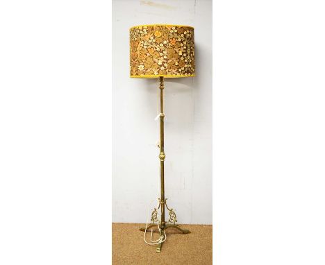 An early 20th Century brass  telescopic standard lamp, the central column above a tripartite base with pierced brass spandrel