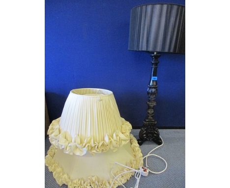 Amodern statement painted black wooden table lamp with a black shade, together with two fancy cream shades