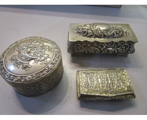 An Edwardian silver trinket box with repousse decoration on bracket feet, Birmingham 1908, makers mark J G, a white metal snu