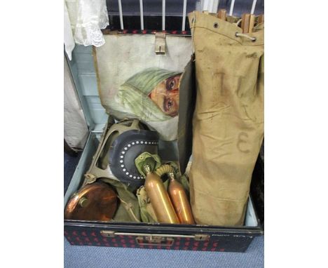 A metal trunk containing two WW2 gas masks, a silk escapee map, a camp bed, an unframed oil on canvas of an Indian soldier, c