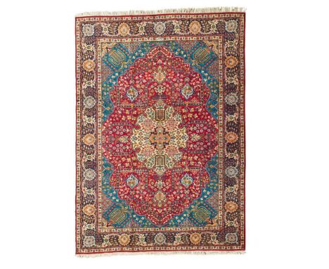 TABRIZ CARPET NORTHWEST PERSIA, MID 20TH CENTURY the red field with cream medallion, turquoise spandrels, within indigo borde