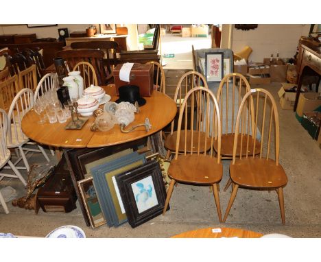 A blonde Ercol drop leaf dining table with a set of six Ercol hoop and stick back dining chairs