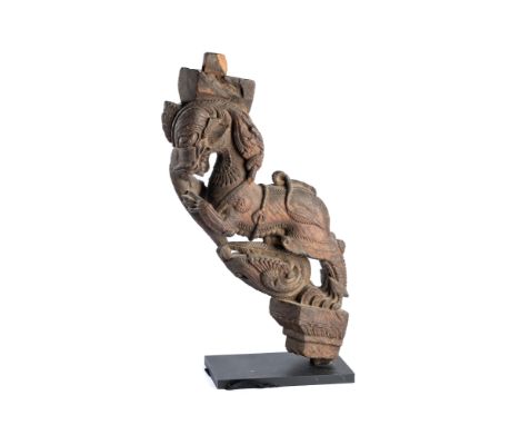 A CARVED WOOD ARCHITECTURAL BRACKET, TAMIL NADU, SOUTH INDIA, 19TH CENTURY in the form of a mythical lion (yali), with long t