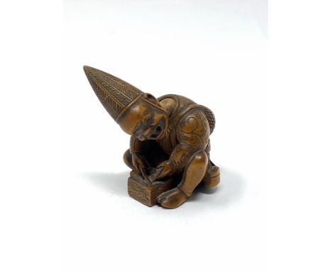 A JAPANESE WOOD NETSUKE, SIGNED MASAYOSHI, NAGOYA, 19TH CENTURY carved as a seated figure sharpening a blade, his movable hea