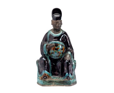A CHINESE FAHUA FIGURE OF A DIGNITARY, LATE MING DYNASTY . seated wearing long flowing aubergine and turquoise-glazed robes a