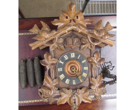 A Black forest cuckoo clock, carved with birds and leaves