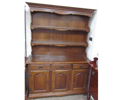 A modern dresser, with a moulded cornice above two shelves, the base with three drawers and three cupboards on bracket feet