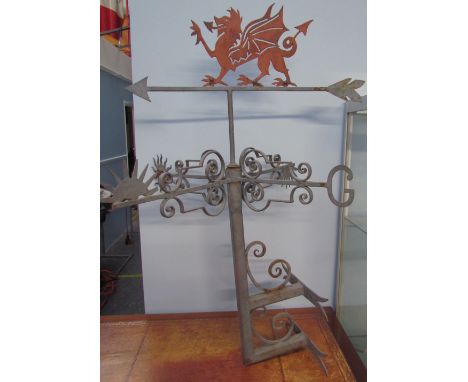 A wall mounted weather vane with a Welsh Dragon surmount