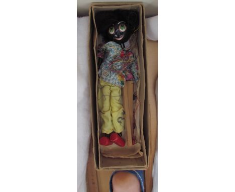 A Pelham puppet of a black marionette together with an Armand Marseille bisque head dolls and a casting of a child's shoe