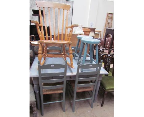 A painted pine kitchen table together with a set of four ladder back dining chairs, a pair of stools and a slat back rocking 