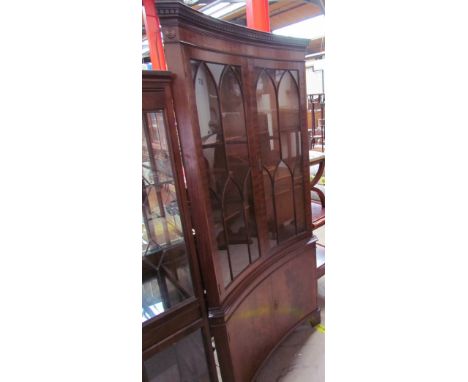 A reproduction mahogany standing corner cupboard of dished form with glazed cupboard doors and a pair of cupboard doors to th
