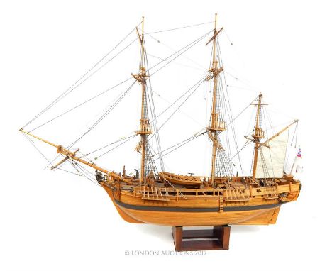 A wooden plank built model of the HMS Bounty with stand; approximately 93cm long overall.