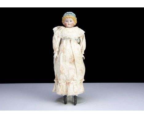 A German 1054 bisque shoulder head doll with moulded hat, with head turned slightly to right, blue painted eyes, closed mouth