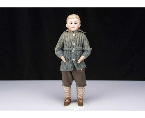 A German bisque shoulder head boy doll with glass eyes and moulded hair,  with blue striated glass eyes, light brown brows, c