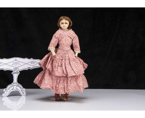 An English poured wax shoulder-head child doll, probably Pierrroti with inset blue glass eyes, inserted brown hair, brass tie