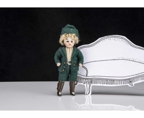 A German all-bisque boy dolls’ house doll, with dark glass eyes, blonde curly mohair wig, fixed neck, jointed at shoulders an