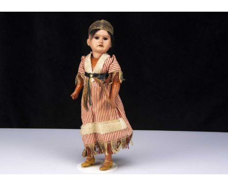 An Armand Marseille Native American Indian squaw, with light brown bisque head, fixed brown class eyes, heavy brow and promin