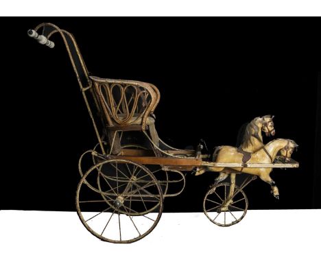 An early 20th century child’s perambulator with two carved and painted wooden galloping horses,  the wicker seat with oil-clo