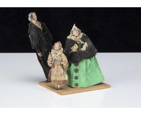 An unusual 19th century paper model of preacher, woman and girl, the preacher in black gown with mutton chops and kind expres
