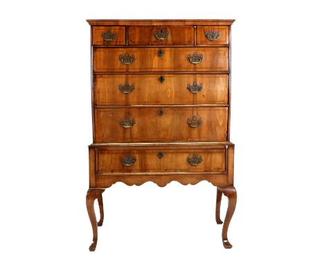 A George I Walnut and Crossbanded Chest on Stand, early 18th century, the moulded top above three short and three long gradua