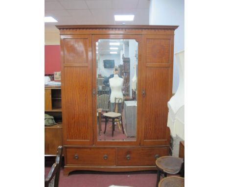 An Early XX Century Satinwood Triple Wardrobe, with stepped pediment, central mirror door flanked by cupboard doors over two 