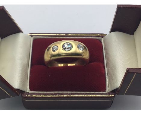 A heavy 18ct gold 3 diamond gypsy ring set with a central stone approximately 0.50ct flanked by 2 smaller stones 0.25ct. Weig