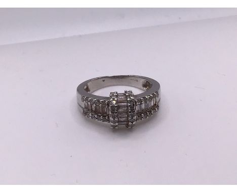 A 14ct white gold brilliant and baguette diamond cluster ring, Size K, (A).