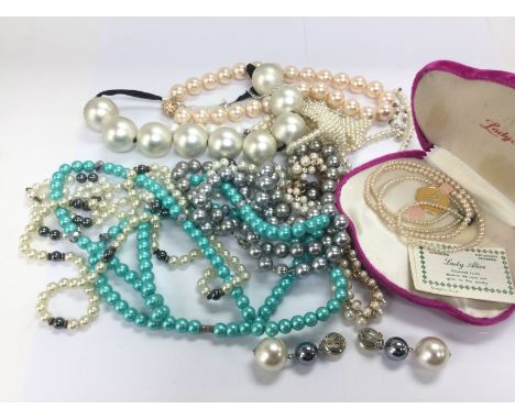 A collection of pearl necklaces and a pair of earrings.