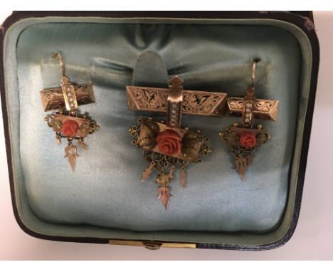 A Victorian coral and seed pearl matching brooch and earrings set with foliage design 6 cm an 5 cm In length.fitted in fitted