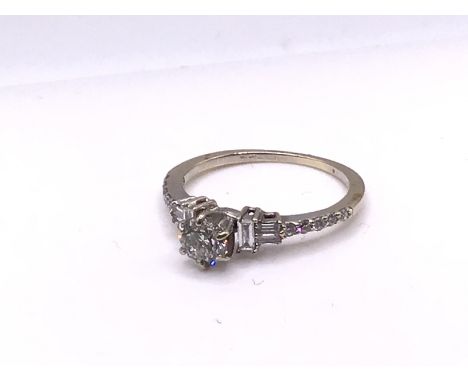 An 18ct white gold round, brilliant and baguette cut diamond ring, Size K, (A).