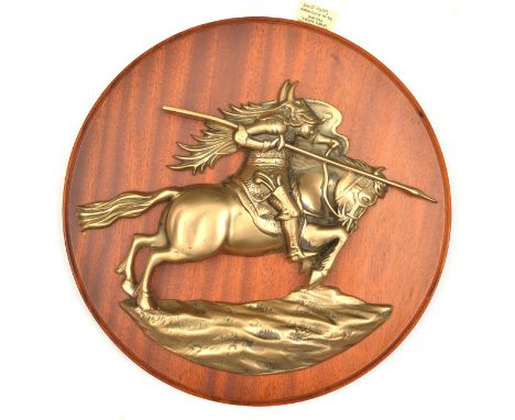 A cast brass badge of HMS Resolution, battleship 1915-48, showing a mounted warrior in horned helmet with flowing mane, chain
