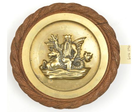 A small cast brass tompion badge of HMS Neptune, battleship 1909-22, showing the sea god holding trident, astride a winged se