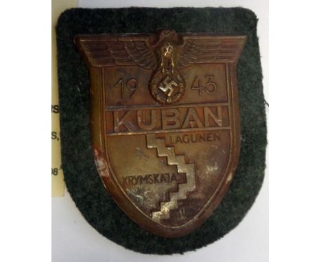 A Third Reich Kuban arm shield,  of bronzed zinc on field grey cloth patch with backing plate and paper backing. GC          