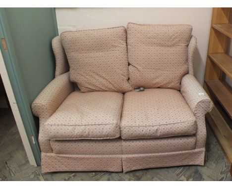 A modern pink upholstered two seater sofa