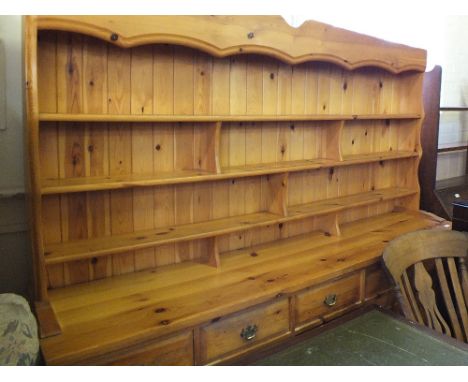 A long modern Pine shelf back dresser with five drawers over four cupboards below