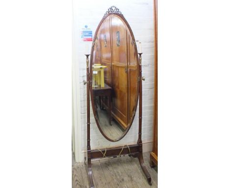 A Mahogany and parcel gilt oval cheval mirror with light fittings either side of the mirror 
