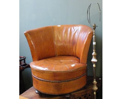 A brown leather tub chair and an onyx and gilt metal standard lamp