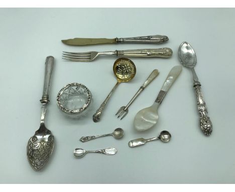 A Lot of silver flatwares which includes Sheffield silver ladle, Silver and mother of pearl pickle fork, 3 Silver salt spoons