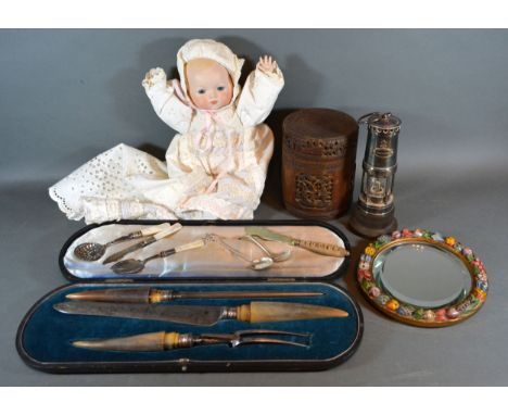 A Horn Handled Carving Set together with other items to include a bisque head doll, a circular wall mirror and a copy of a mi