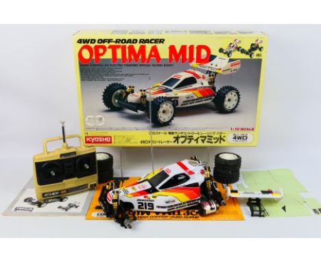 Kyosho - A boxed vintage electric powered radio controlled Kyosho #3135 1:10 scale Optima Mid 4WD Off Road Racer. The assembl