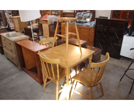 A light wood kitchen table; three spindle back chairs and a stool