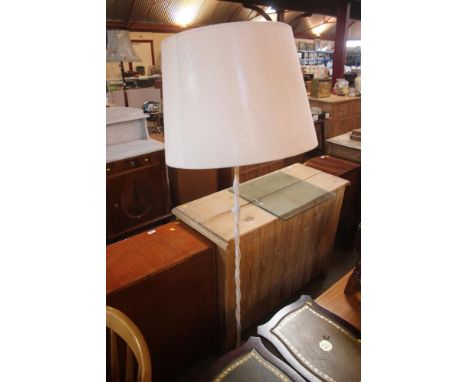 A white painted wrought iron standard lamp and shade
