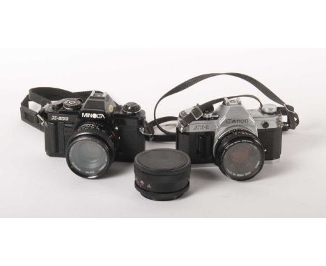 A collection of vintage cameras and lenses, including a Canon AT 1 SLR camera together with a Minolta X-500 SLR camera