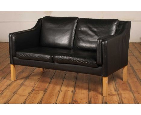 In the manner of Borge Mogensen, a Danish black leather two seater sofa, 78 x 150 x 72cm