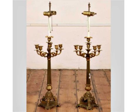 A pair of gilt six branch table candelabra, 19th century, in the Rococo style, each upon a triform base, later converted into