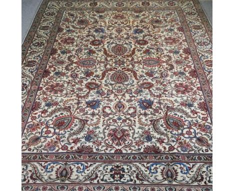 A Persian Tabriz carpet, decorated with foliage upon a cream ground within multiple borders, 372 x 278cm