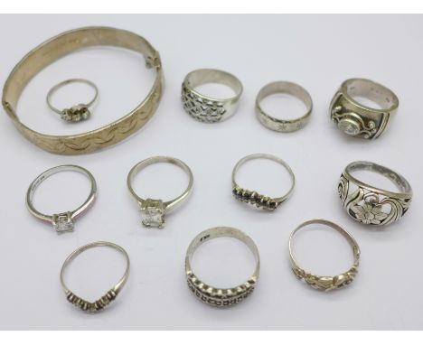 Eleven silver rings and a silver bangle